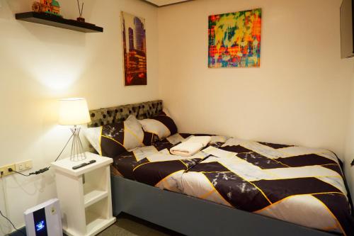 a bedroom with a bed and a lamp on a table at Sunset View Ridge Residences in Baguio
