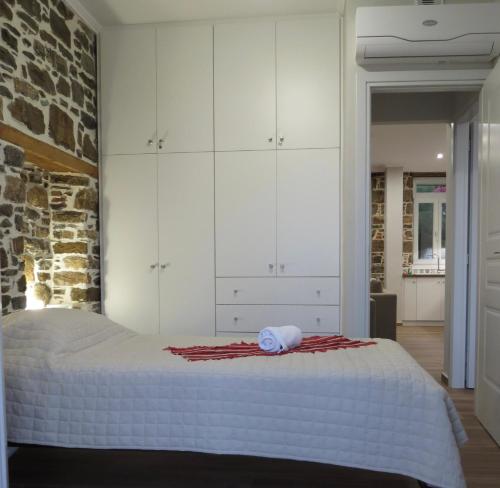 a bedroom with a large bed with white cabinets at Rodonas-Apartments in Volissos