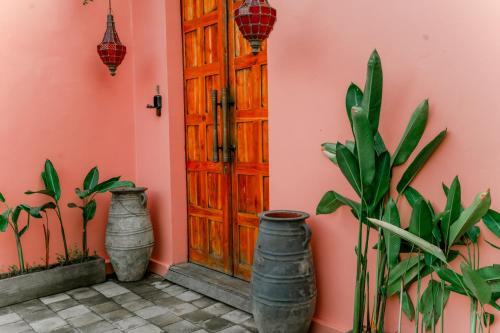 a door with three vases next to a pink wall at La Marrocco Villas in Nusa Penida