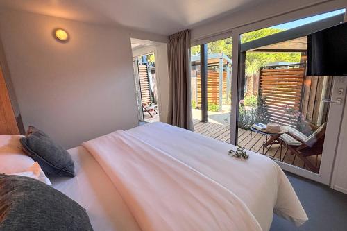 a bedroom with a bed and a balcony with a view at Waterman Beach Village in Supetar