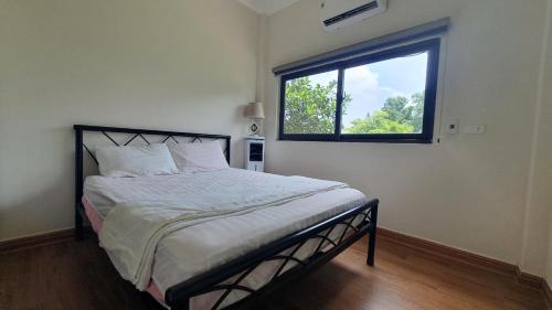 a bedroom with a large bed with a window at Thanh Xuân Ecolodge in Ðào Lãng
