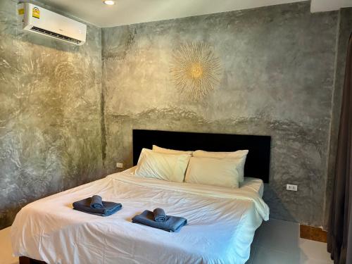 a bedroom with a bed with two towels on it at Chook Dee Resort in Baan Tai