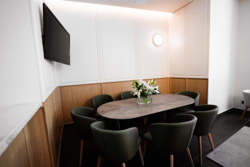 a dining room with a table and green chairs at FortyPlusOne Hotel Vienna in Vienna