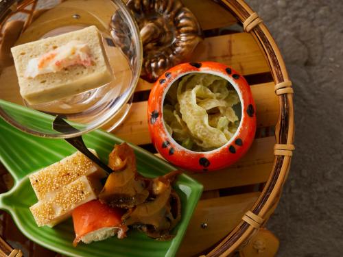 a tray with a plate of food and a bowl of dip at KAMENOI HOTEL Fukui in Fukui