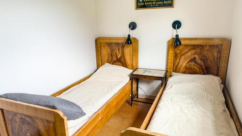 two twin beds in a room with a table and lamps at VILLA ORANGE - Spacious piano home in Klaksvik in Klaksvík