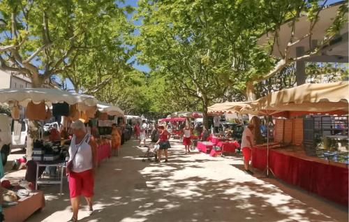 a group of people walking through a market with umbrellas at Awesome Home In Connaux in Connaux