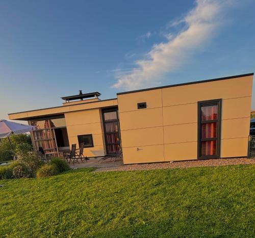 a large yellow building on the side of a yard at Marina Strandbad Chalet RiverLodge mit Zaun Haus Nr 94 in Olburgen