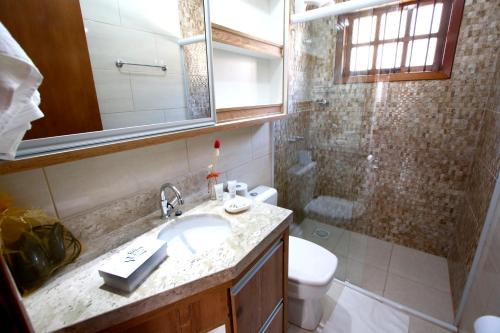 a bathroom with a sink and a toilet and a shower at Pousada Monte Bello Canela in Canela
