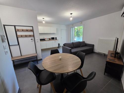 un salon avec une table, des chaises et un canapé dans l'établissement T2 avec parking aux portes de montpellier, à Castelnau-le-Lez