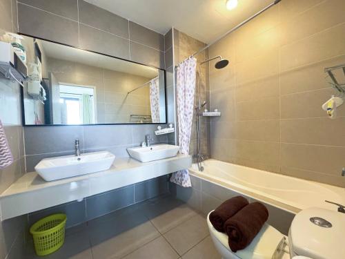 a bathroom with two sinks and a toilet and a mirror at Zeta Residence One South with City View n Private Lift, Seri Kembangan Selangor in Serdang