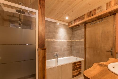 a bathroom with a tub and a sink at La Petite Serenne - Vue Montagne 