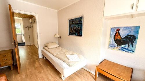 a room with a bed and a painting of a rooster at VILLA ORANGE - Spacious piano home in Klaksvik in Klaksvík