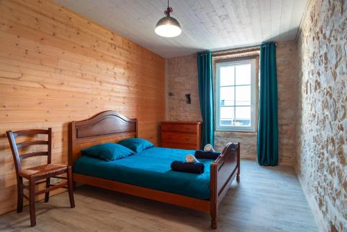 a bedroom with a bed and a chair in it at Ty Penn Ar Bed - Proche de la Plage in Plomodiern