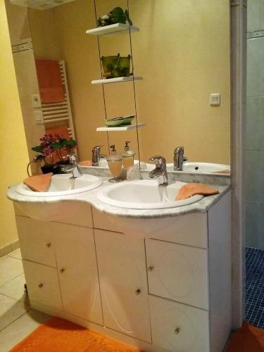 a bathroom with two sinks and a mirror at Les Chambres de la Nied in Condé-Northen