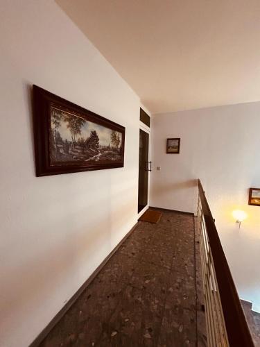 a hallway with a painting on a white wall at P1 Teams zentral I150m2 I EG für 6 I Wasch I P I in Ibbenbüren
