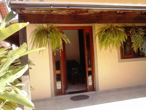 Paraiso de Itaipu في Itaipu: منزل به اثنين من النباتات الفخارية