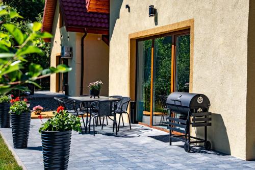 a patio with a grill and a table and chairs at Dom w Karkonoszach 2 in Podgórzyn
