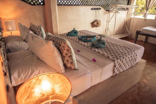 a bed in a room with two stuffed animals on it at Banana House and Wellness Centre in Lamu