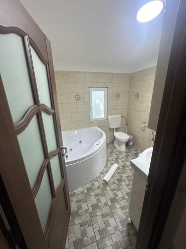 a bathroom with a tub and a toilet and a sink at Riz apartamant in Bacău