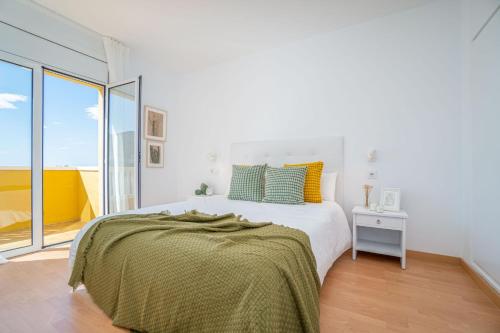 a white bedroom with a bed and a window at Milenial Immo Almadrava Roses Beach House in Roses