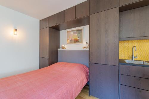 une petite chambre avec un lit et un lavabo dans l'établissement Coeur de Versailles - Vue jardin apaisante & calme, à Versailles