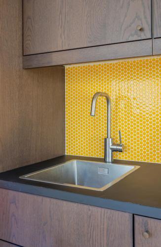Il comprend une cuisine avec un évier et un mur carrelé jaune. dans l'établissement Coeur de Versailles - Vue jardin apaisante & calme, à Versailles