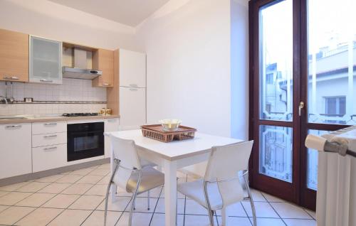 a kitchen with a white table and white chairs at Beautiful Apartment in Santa Maria di Castellabate