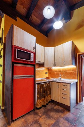a kitchen with a red refrigerator and a sink at Apartamentos Rurales & Spa La Bárcena in Enterria