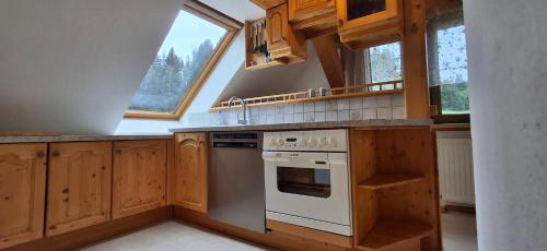 a kitchen with wooden cabinets and a white stove top oven at Appartements Scharzenberger und Hinteregg in Schladming
