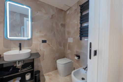 a bathroom with a sink and a toilet and a mirror at Luna Stay in Trieste