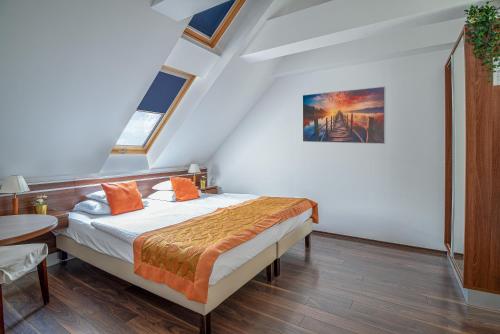 una camera da letto con un letto con cuscini arancioni sopra di Vinosseum Bor- és Apartmanház a Sopron