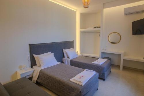 a hotel room with two beds and a couch at Aegean Sunset Loft in Rhodes Town
