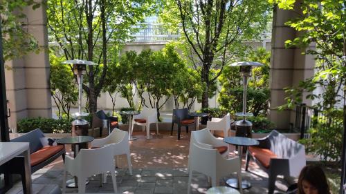 a patio with tables and chairs and trees at Executive Hotel Vintage Park in Vancouver