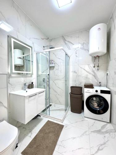 a white bathroom with a washing machine and a washer at Apartment BAR M3A sea view in Bar