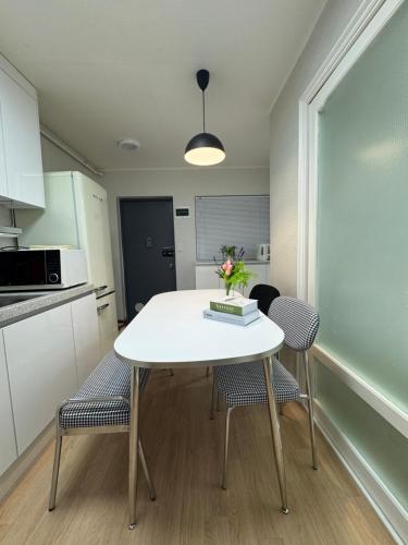 a kitchen with a white table and two chairs at Hi Seoul Daechi in Seoul