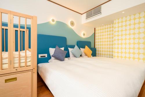 a bedroom with a white bed and blue walls at KAMENOI HOTEL Atami in Atami
