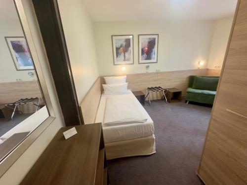 a hospital room with a bed and a couch at Hotel Central in Bamberg