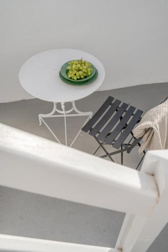 a white table with a plate of grapes and a chair at Yposkafon Concept Two-Bedroom Villa with Private Jacuzzi and Hamam in Megalokhori
