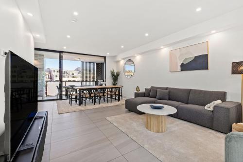 a living room with a couch and a table at Big Two-Story with Private Elevator & Balconies in Sydney