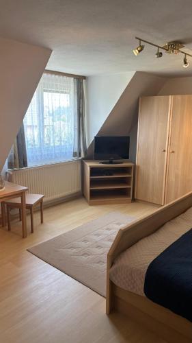 a bedroom with a bed and a tv and a window at Ferienhaus Maria in Eibiswald