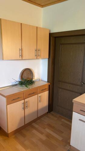 a kitchen with wooden cabinets and a door in a room at Ferienhaus Maria in Eibiswald
