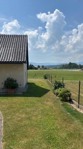 a building in a field next to a fence at Ferienhaus Maria in Eibiswald