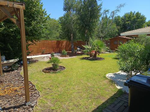 a backyard with a garden with plants and a fence at XAN in Biganos