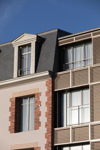 une image d'un bâtiment avec fenêtres dans l'établissement Hotel de la Plage, à Erquy