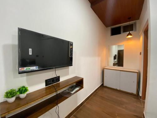 a living room with a flat screen tv on a wall at Wildscape kaziranga in Kāziranga