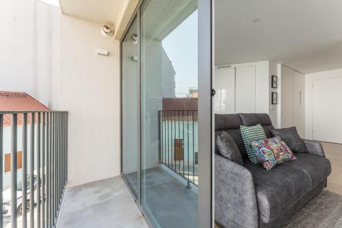 a living room with a couch and a glass wall at GuestReady - Relaxing Getaway Near Porto in Vila Nova de Gaia