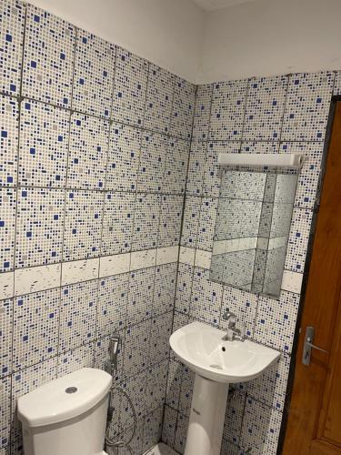 a bathroom with a toilet and a sink at Maison Royale in Kofa