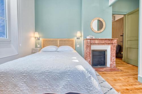 a bedroom with a large bed and a fireplace at Appartement Climatisé, 2 personnes in Eymet