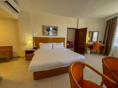 a hotel room with a large bed and a desk at Aqaba Gulf Hotel By FHM in Aqaba