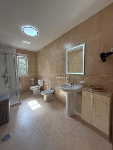 a bathroom with two toilets and a sink and a shower at Casa SobreMonte in Muxia